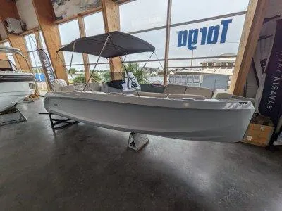 2023 Rand Source 22 boat displayed indoors with canopy and seating.