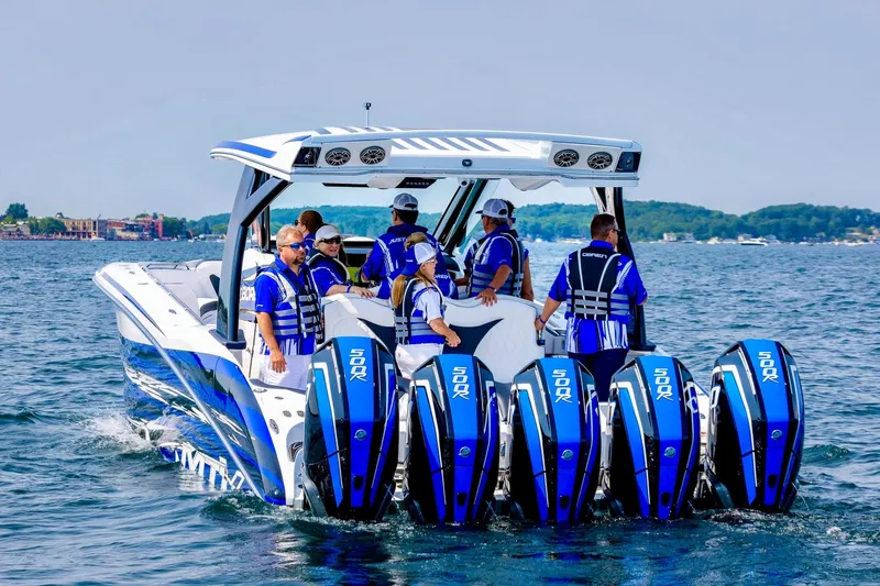  Yacht Photos Pics 2024 MTI V42 boat with multiple engines, cruising on a lake with passengers.