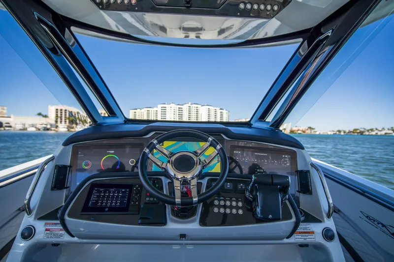  Yacht Photos Pics 2024 MTI V42 boat dashboard with advanced navigation system and scenic waterfront view.