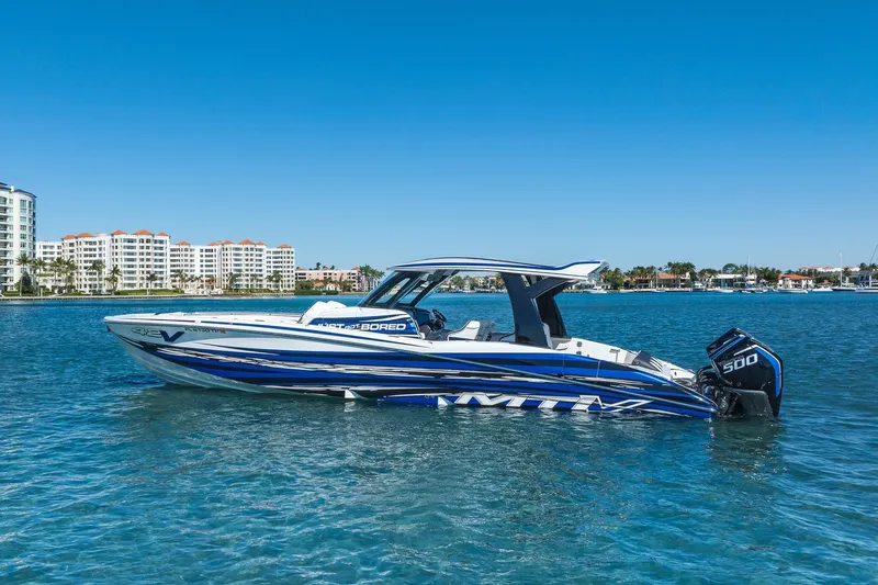  Yacht Photos Pics 2024 MTI V42 boat on clear blue water with cityscape background.