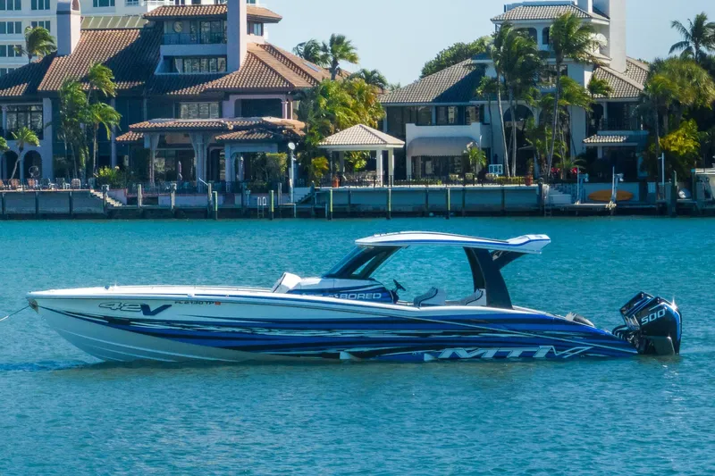  Yacht Photos Pics 2024 MTI V42 boat on water with luxury waterfront homes in the background.