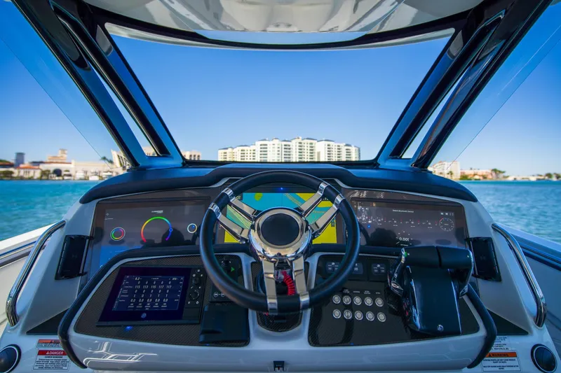  Yacht Photos Pics Cockpit view of 2024 MTI V42 boat with advanced navigation system and steering wheel.