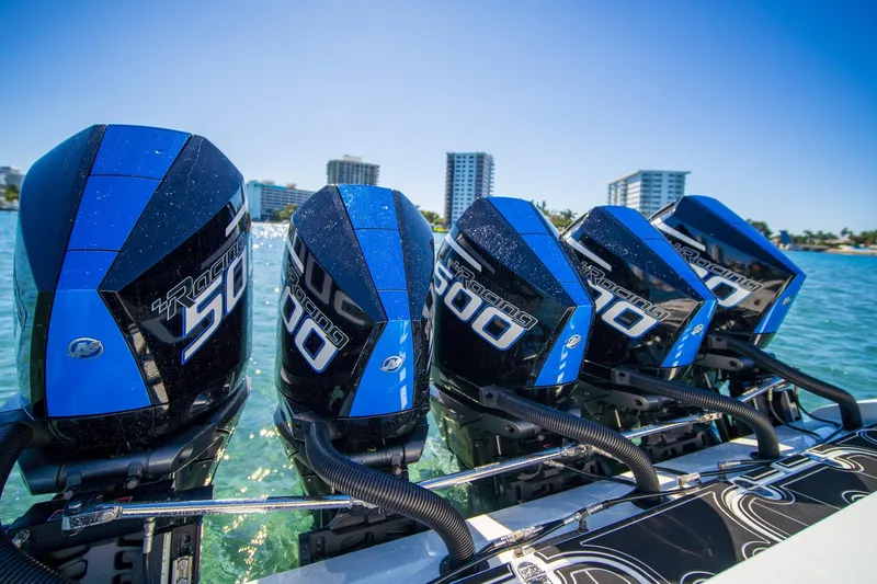  Yacht Photos Pics Four powerful outboard motors on a 2024 MTI V42 boat, with a cityscape backdrop.