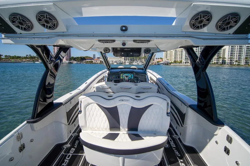 Yacht Photos Pics 2024 MTI V42 luxury boat interior with sleek seating and advanced dashboard on calm water.