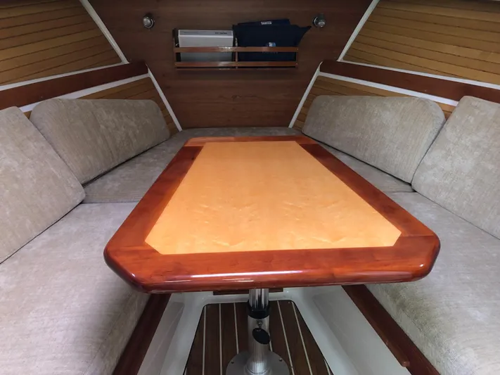 Act III Yacht Photos Pics Interior of 2008 Back Cove 29 boat with wooden table and cushioned seating.