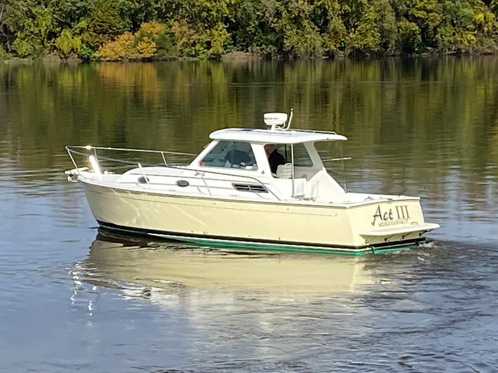 Act III Yacht Photos Pics 2008 Back Cove 29 boat cruising on calm water with lush green background.