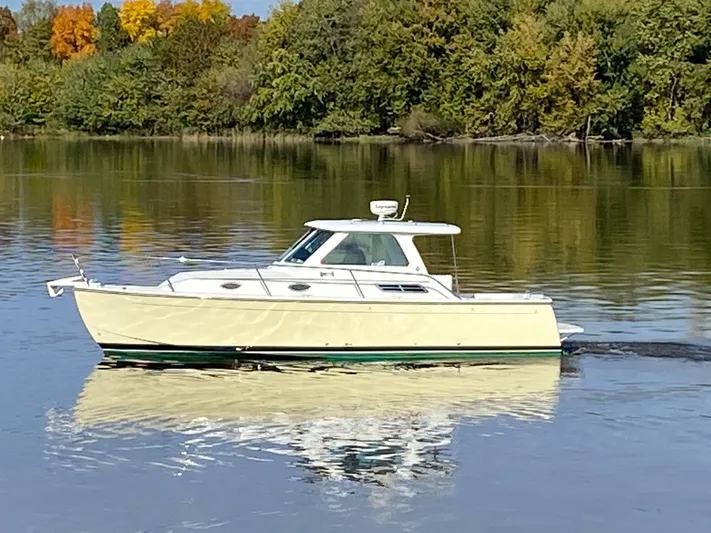 Act III Yacht Photos Pics 2008 Back Cove 29 boat cruising on a calm lake with autumn trees in the background.