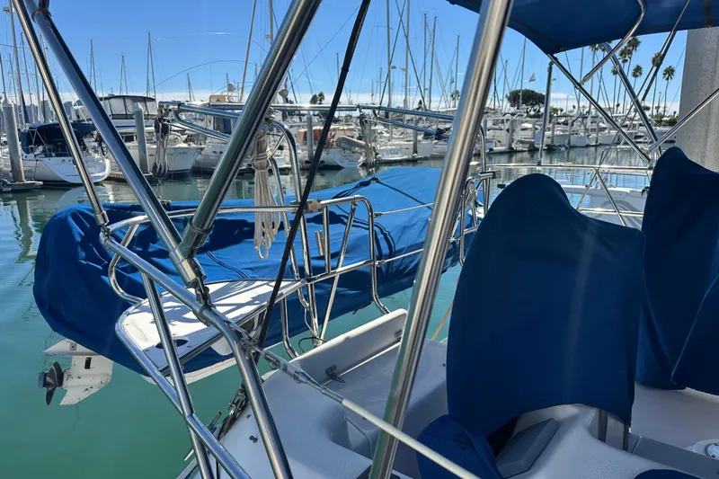 True North Yacht Photos Pics 2003 Catalina 470 sailboat docked in marina, featuring blue covers and stainless steel railings.