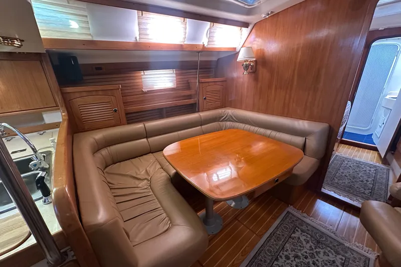 True North Yacht Photos Pics Luxurious interior of 2003 Catalina 470 yacht with wooden dining area and leather seating.