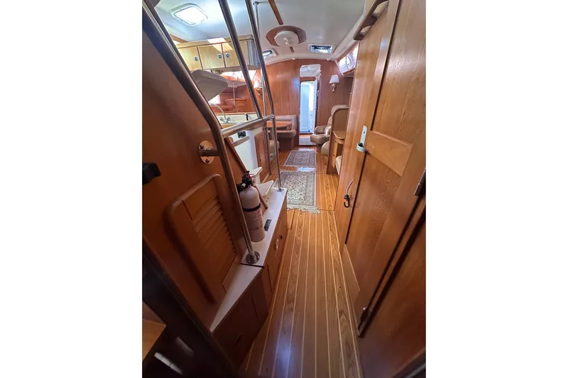 True North Yacht Photos Pics Interior of 2003 Catalina 470 sailboat with wooden flooring and cozy seating area.