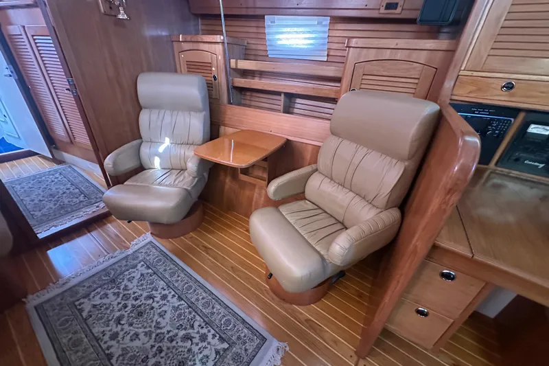 True North Yacht Photos Pics Luxurious interior of 2003 Catalina 470 yacht with leather chairs and wooden accents.