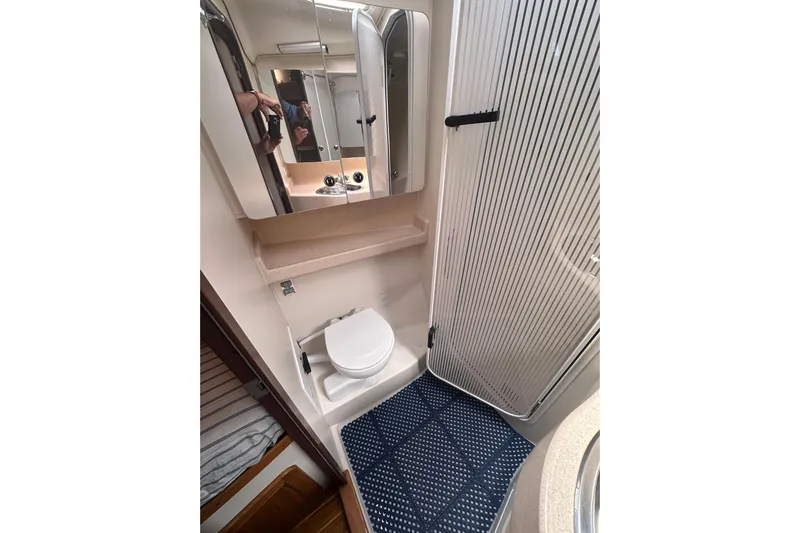 True North Yacht Photos Pics Compact bathroom in 2003 Catalina 470 yacht with toilet, mirror, and shower.