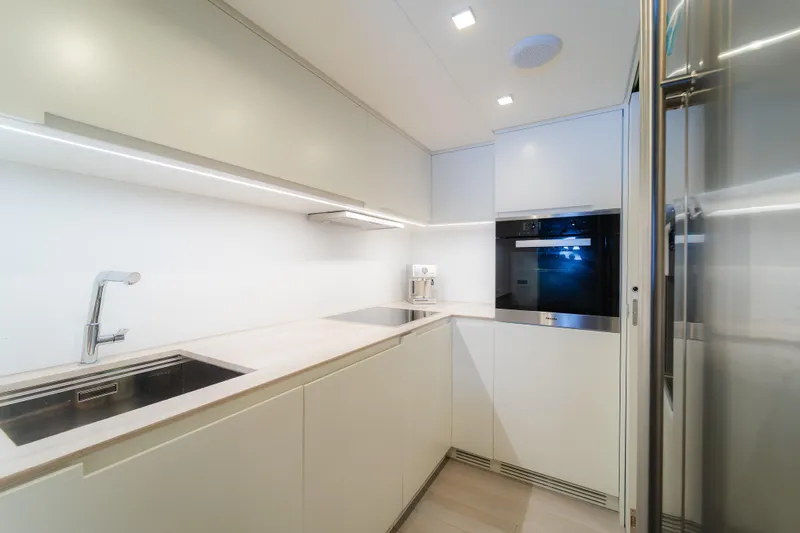 Nova Yacht Photos Pics Modern kitchen interior on 2021 Pershing 8X yacht, featuring sleek cabinetry and built-in appliances.