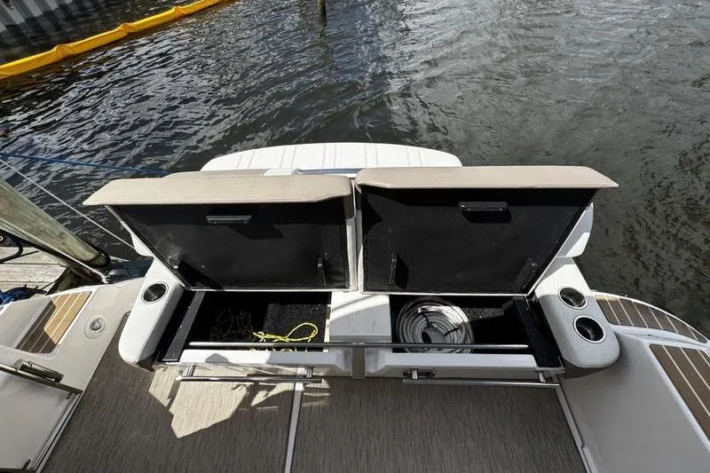  Yacht Photos Pics 2018 Regal 35 Sport Coupe boat with open storage compartments by the water.