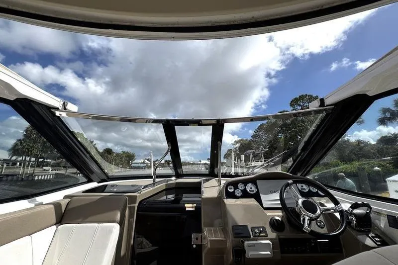  Yacht Photos Pics Interior view of 2018 Regal 35 Sport Coupe boat cockpit under a partly cloudy sky.