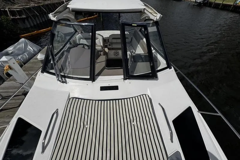  Yacht Photos Pics 2018 Regal 35 Sport Coupe boat with open cockpit, docked by the water.