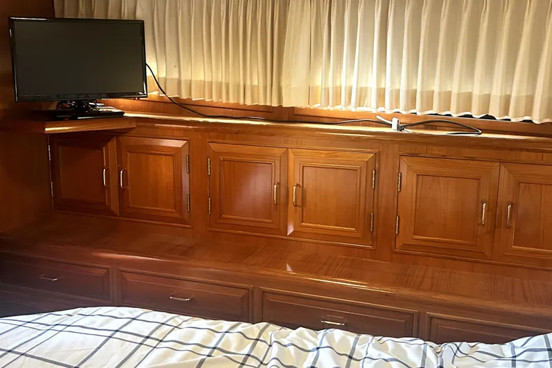 Chrysalis Yacht Photos Pics Interior of 1989 Ocean Alexander 44 CPMY with wood cabinetry and mounted TV.