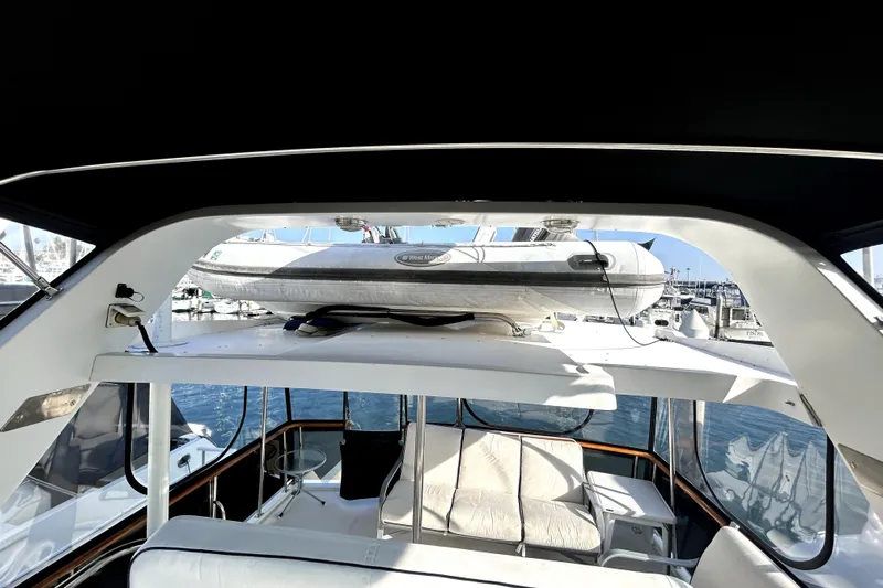 Chrysalis Yacht Photos Pics 1989 Ocean Alexander 44 CPMY yacht interior with inflatable boat on deck, docked at marina.