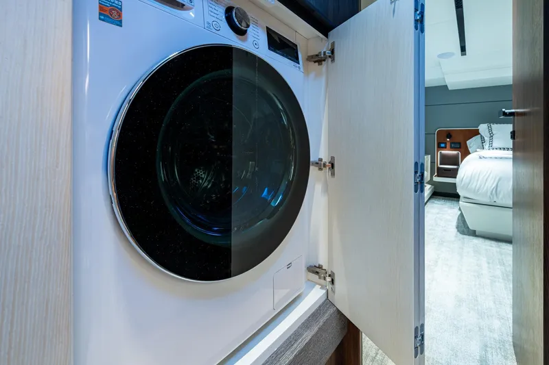 Alamar Yacht Photos Pics 2023 Astondoa AS5 yacht interior with built-in washing machine and bedroom view.