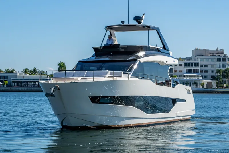 Alamar Yacht Photos Pics 2023 Astondoa AS5 yacht cruising on a sunny day near modern waterfront buildings.