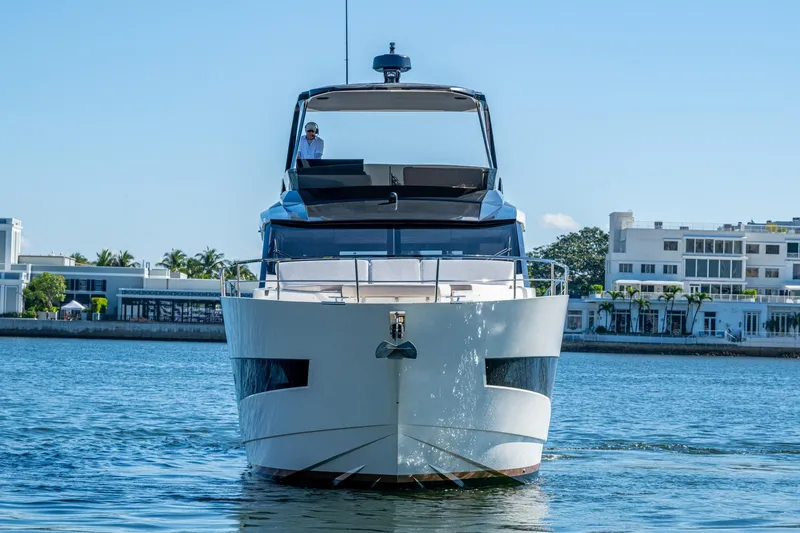 Alamar Yacht Photos Pics 2023 Astondoa AS5 yacht cruising on a sunny day near waterfront buildings.