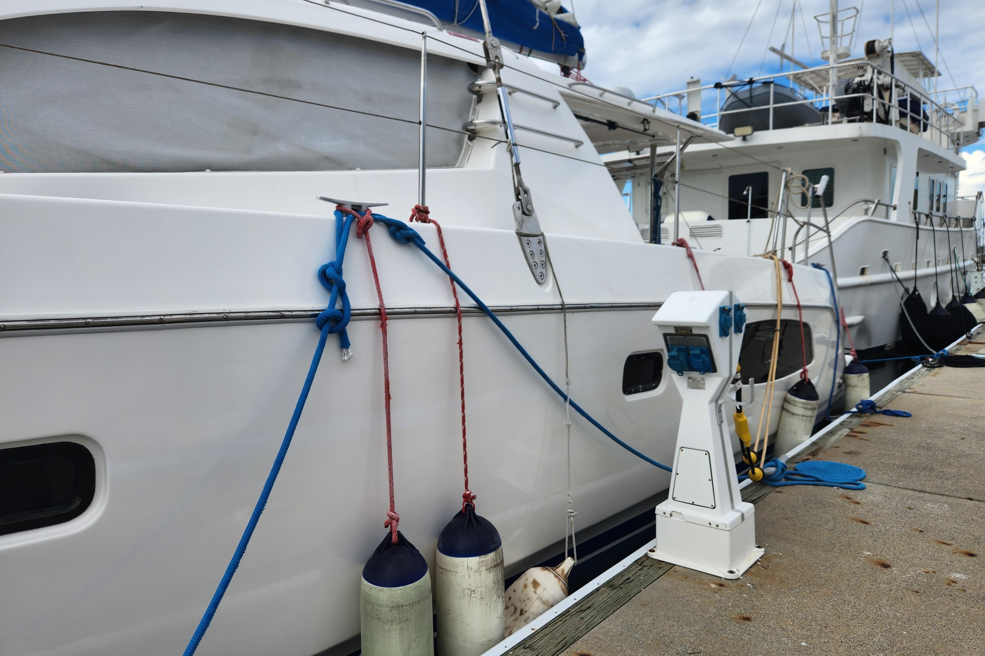 2015 Leopard 44 yacht docked with fenders and ropes, marina setting.