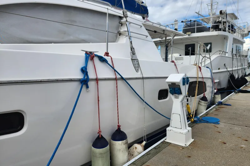 Cara Lynn Yacht Photos Pics 2015 Leopard 44 yacht docked with fenders and ropes, marina setting.