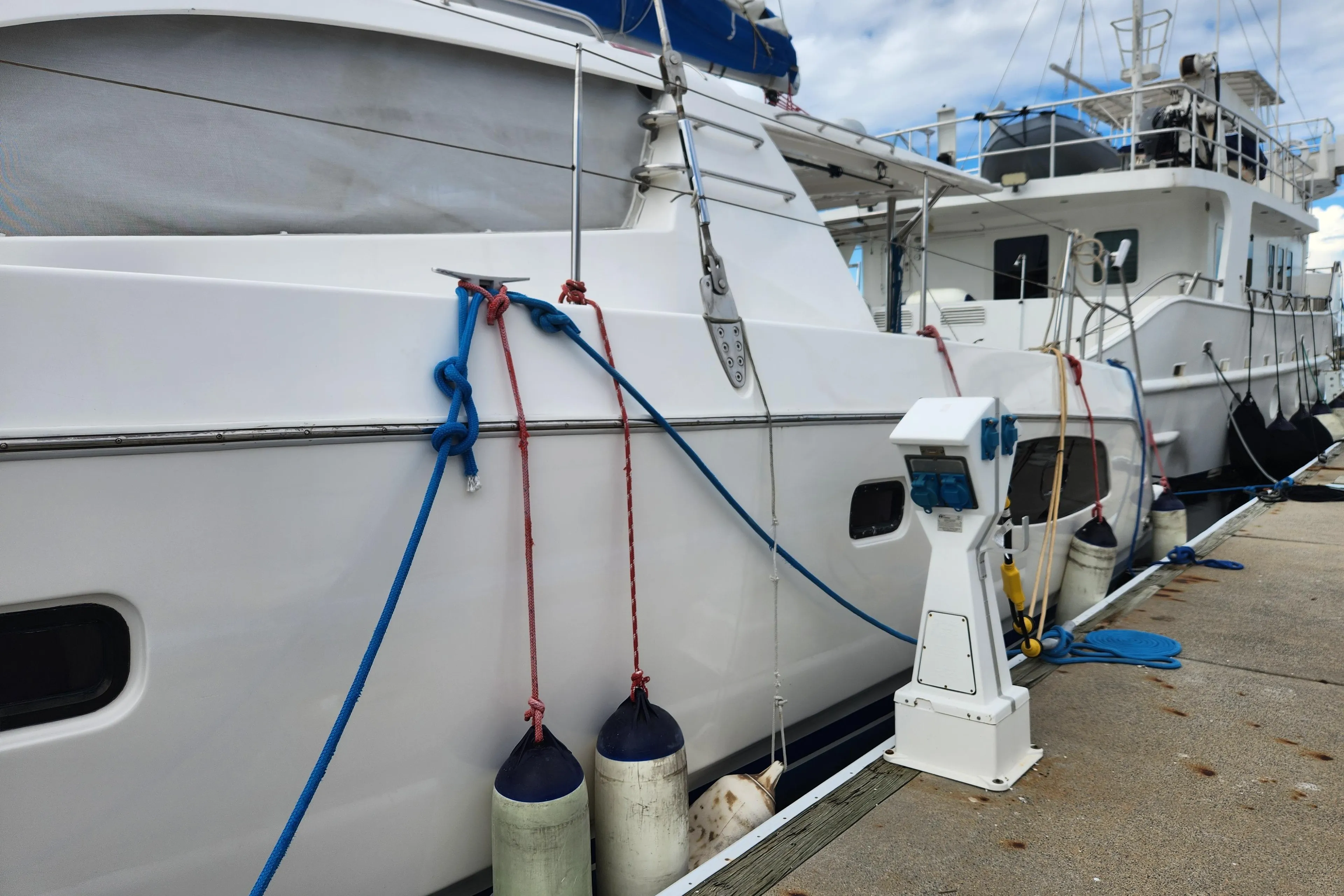 2015 Leopard 44 yacht docked with fenders and ropes, marina setting.