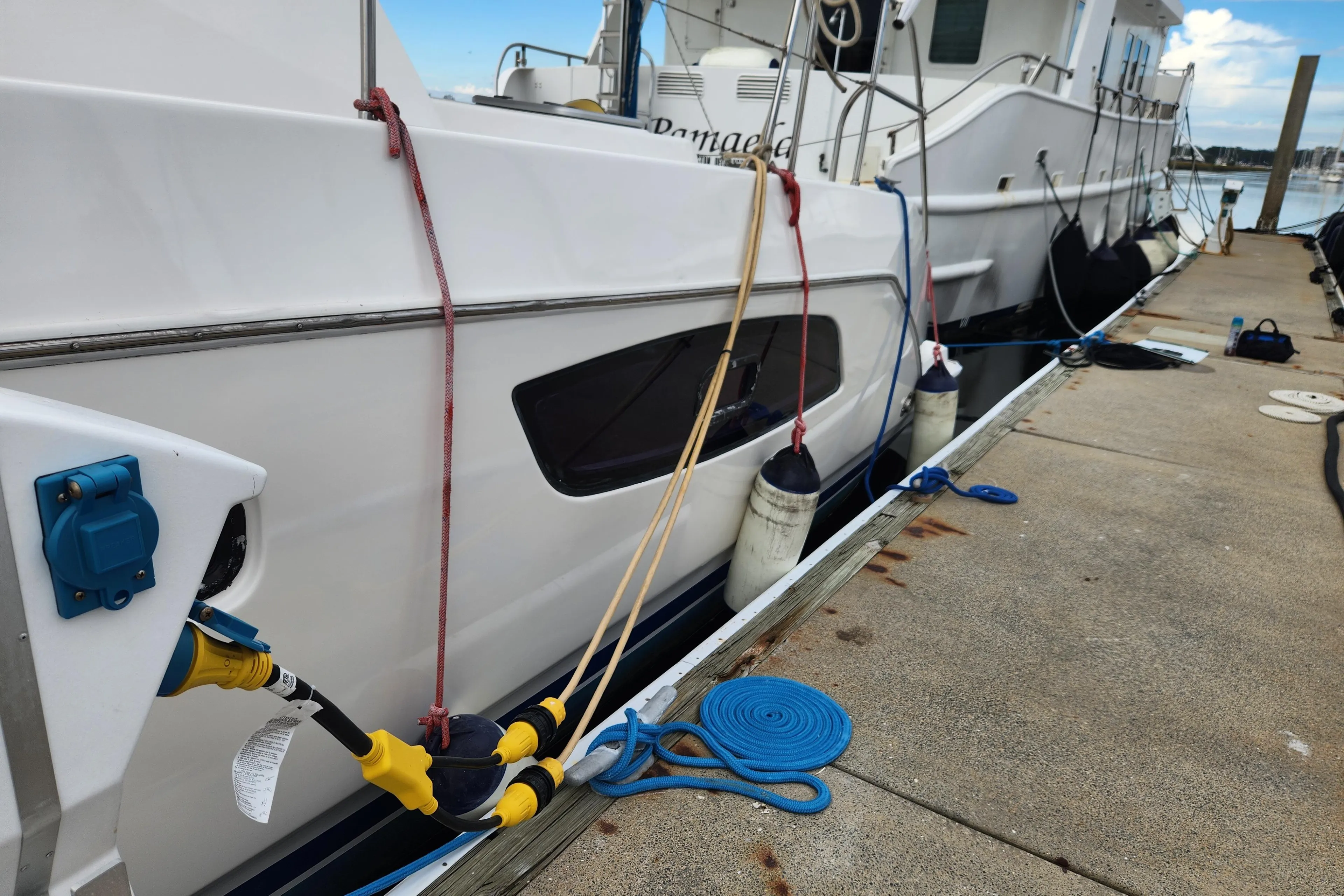 Docked Leopard 44 catamaran yacht with mooring lines and power connections, 2015 model.