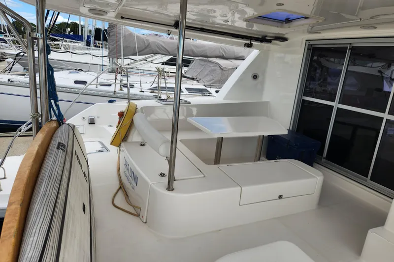 Cara Lynn Yacht Photos Pics 2015 Leopard 44 catamaran cockpit with seating and table, docked at marina.