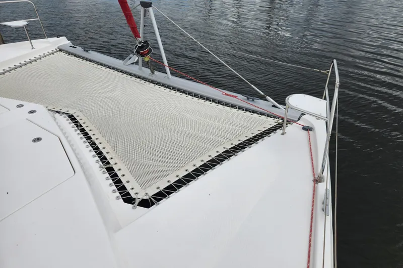 Cara Lynn Yacht Photos Pics 2015 Leopard 44 catamaran deck with netting over calm water.