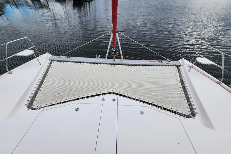 Cara Lynn Yacht Photos Pics Front deck of a 2015 Leopard 44 catamaran with netting over calm water.