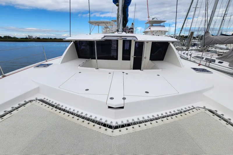 Cara Lynn Yacht Photos Pics 2015 Leopard 44 catamaran deck with netting, docked at marina under blue sky.