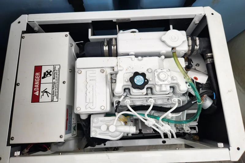 Cara Lynn Yacht Photos Pics Engine compartment of a 2015 Leopard 44, featuring mechanical components and warning labels.