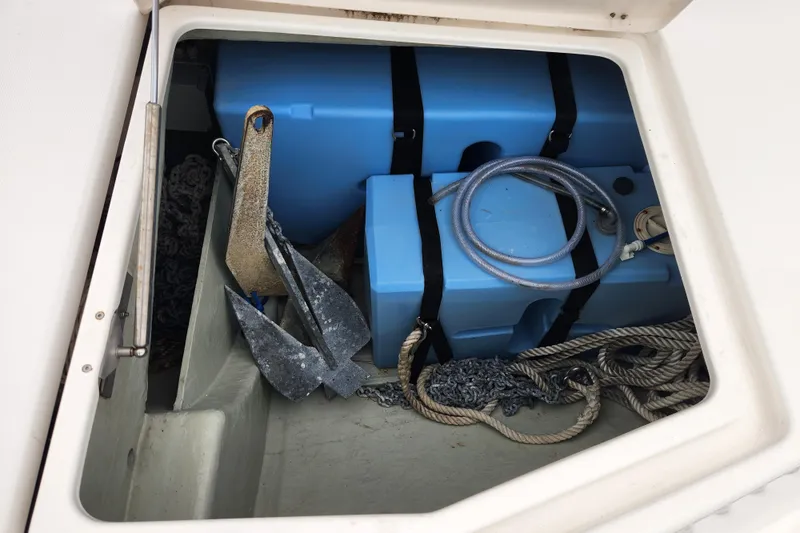 Cara Lynn Yacht Photos Pics Storage compartment on a 2015 Leopard 44 boat with anchor, ropes, and blue containers.