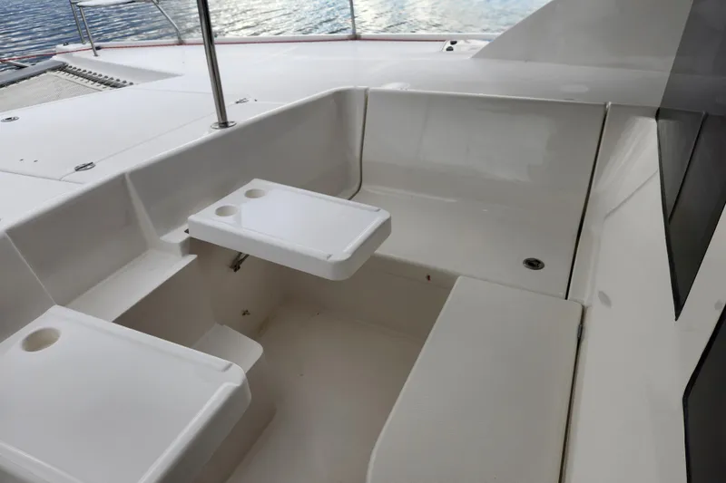 Cara Lynn Yacht Photos Pics 2015 Leopard 44 catamaran cockpit with white seating and table, overlooking water.