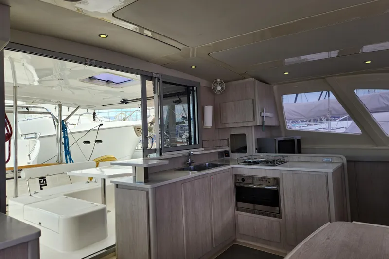 Cara Lynn Yacht Photos Pics Modern kitchen interior on a 2015 Leopard 44 catamaran yacht, featuring sleek cabinetry and appliances.