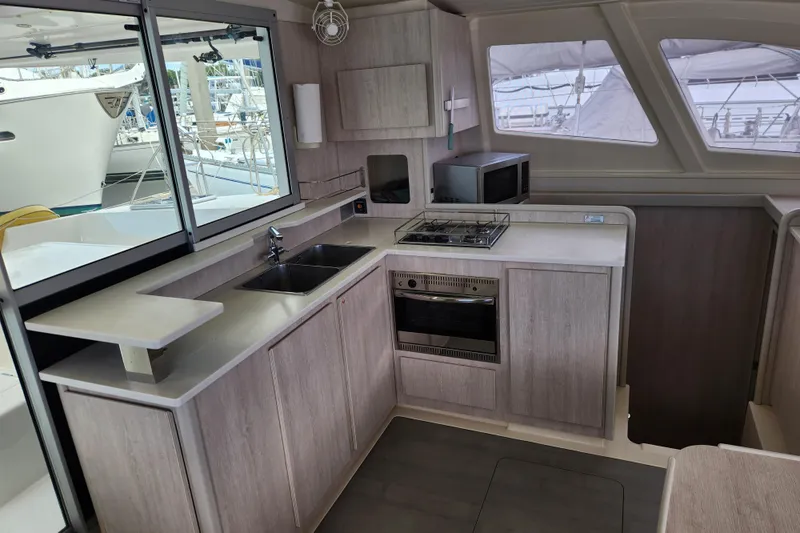 Cara Lynn Yacht Photos Pics Modern kitchen interior of 2015 Leopard 44 yacht with stove, sink, and microwave.
