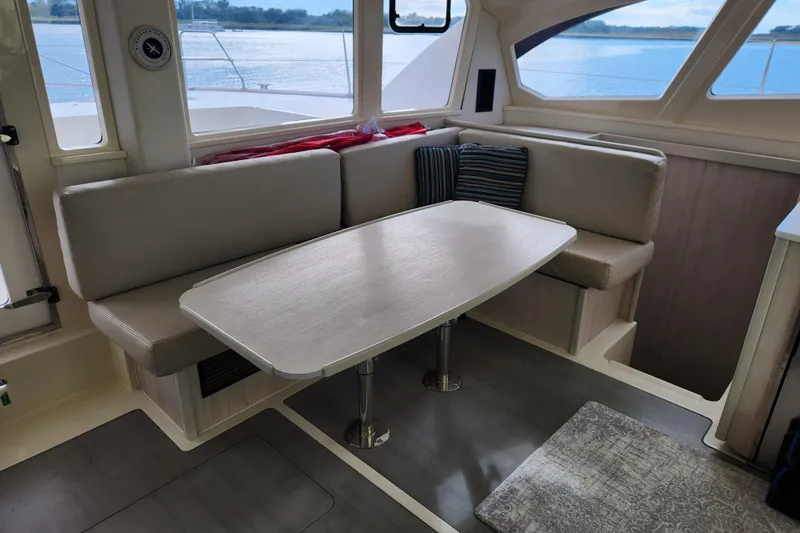 Cara Lynn Yacht Photos Pics Interior of 2015 Leopard 44 yacht with cozy seating and table by windows.