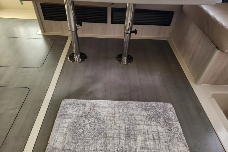 Cara Lynn Yacht Photos Pics Interior of a 2015 Leopard 44 yacht with wooden flooring and a patterned rug.