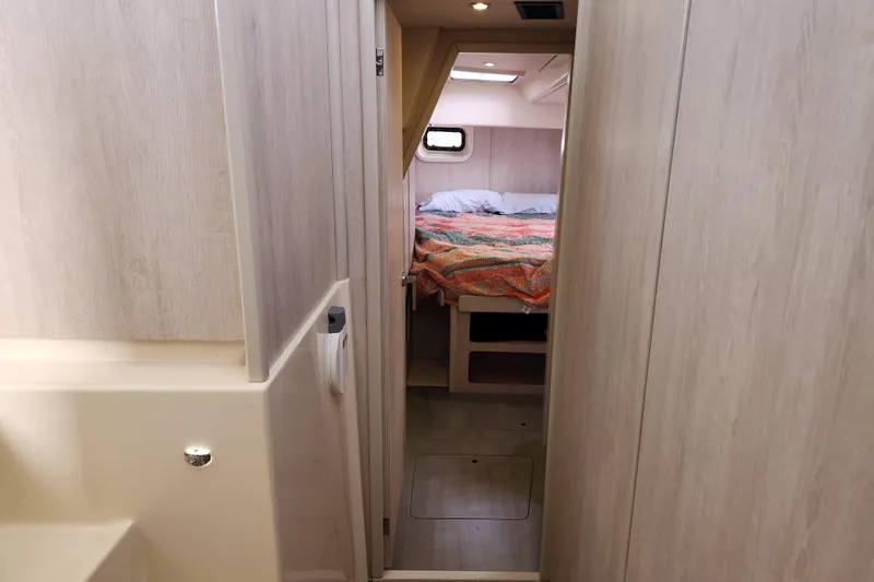 Cara Lynn Yacht Photos Pics Interior of 2015 Leopard 44 yacht showing cozy bedroom with colorful bedding.