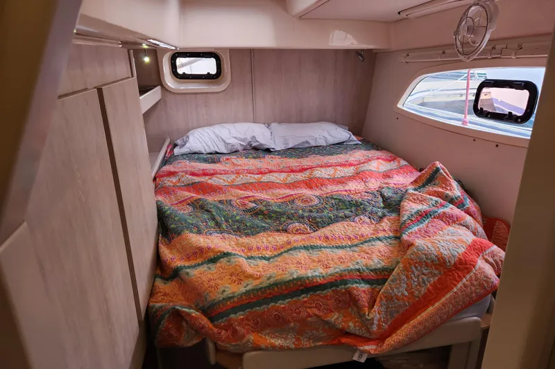 Cara Lynn Yacht Photos Pics Cozy cabin interior of 2015 Leopard 44 yacht with colorful bedding and porthole windows.