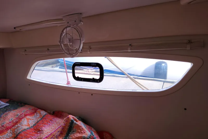 Cara Lynn Yacht Photos Pics Interior view of a 2015 Leopard 44 yacht cabin with window and colorful bedding.