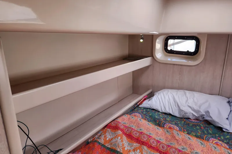 Cara Lynn Yacht Photos Pics Cozy cabin interior of 2015 Leopard 44 yacht with colorful bedding and small window.