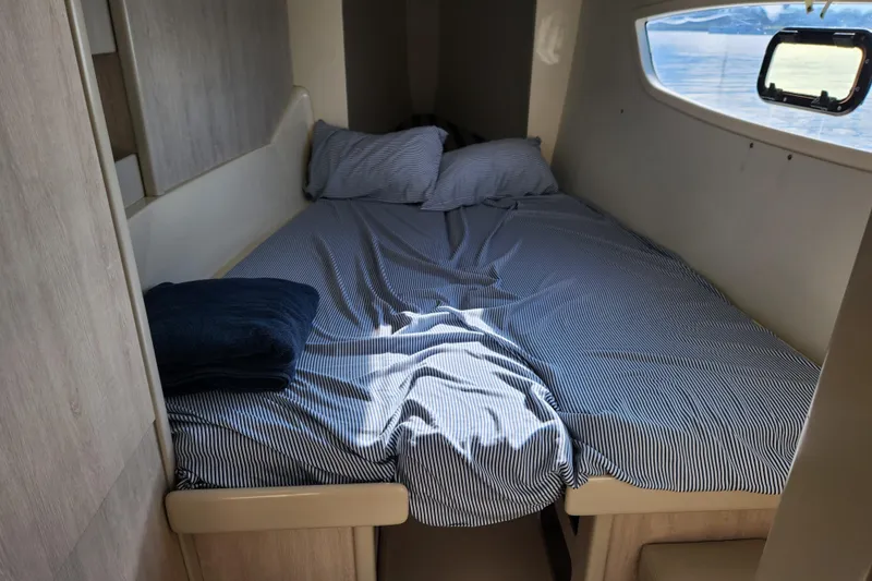 Cara Lynn Yacht Photos Pics Cozy cabin bed in 2015 Leopard 44 yacht with striped bedding and window view.