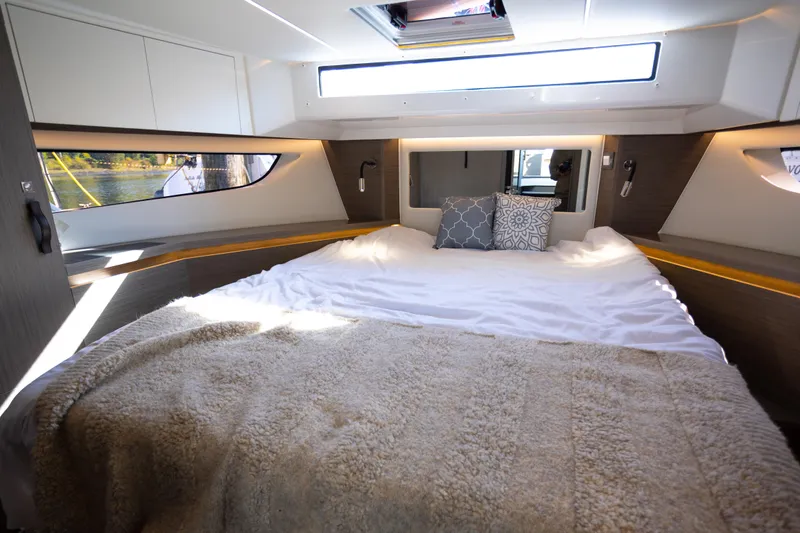 Samadhi Yacht Photos Pics Luxurious cabin interior of 2024 Jeanneau NC 1295 Fly with cozy bedding and modern design.