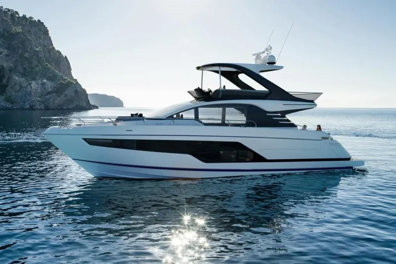  Yacht Photos Pics 2026 Fairline Squadron 58 yacht cruising on serene waters near a rocky coastline.