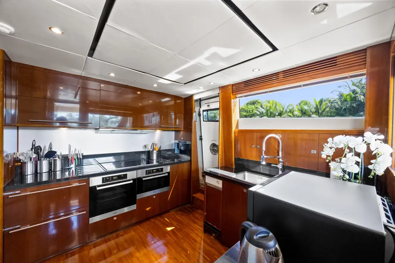Oasis Yacht Photos Pics Luxurious kitchen interior of 2010 Princess 95 Motor Yacht with modern appliances and wood finish.
