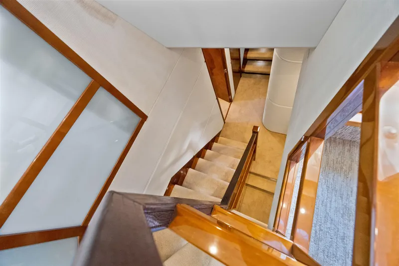 Oasis Yacht Photos Pics Interior staircase of 2010 Princess 95 Motor Yacht, featuring elegant wood and carpet design.