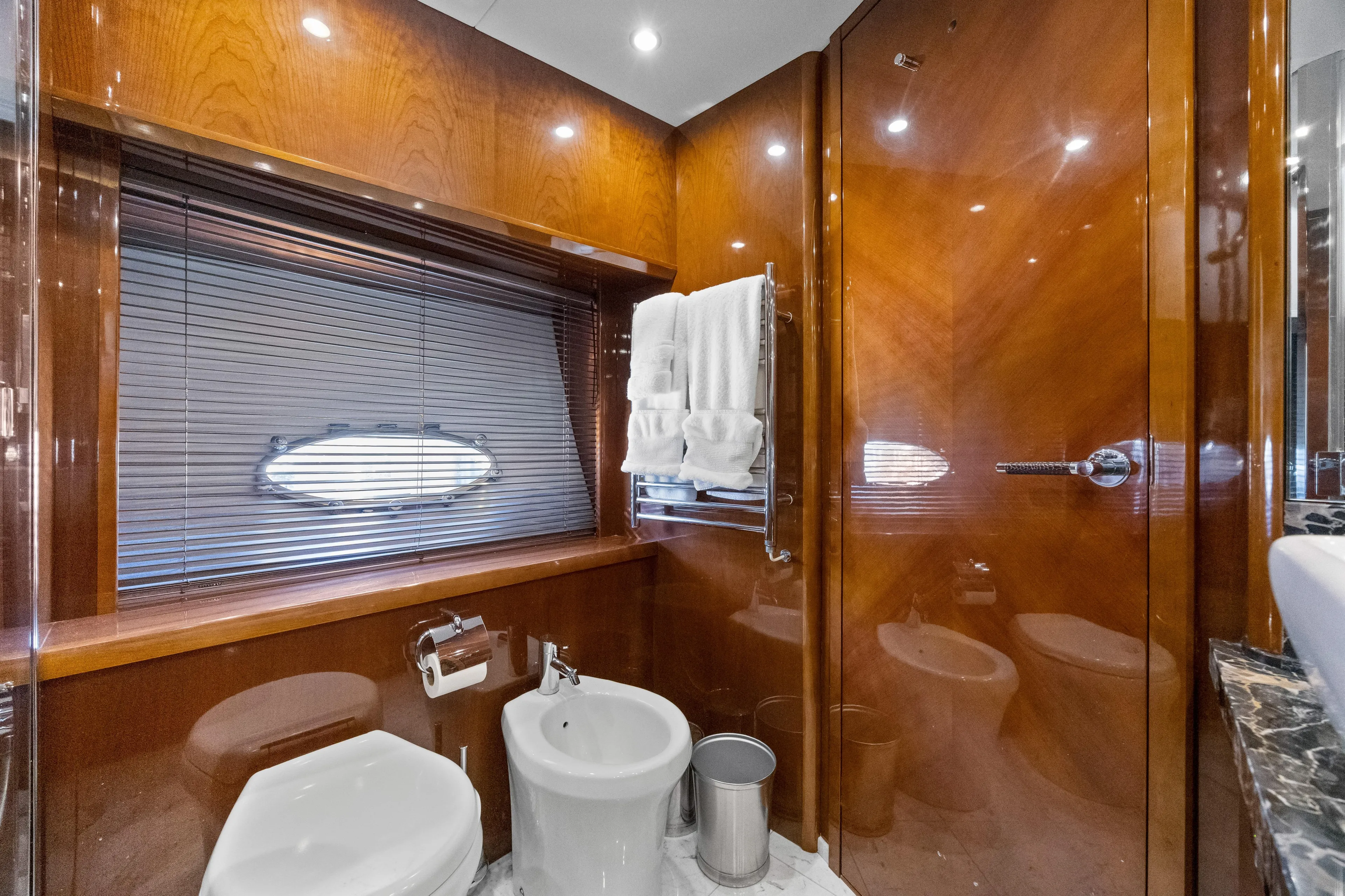 Oasis Yacht Photos Pics Luxurious bathroom on 2010 Princess 95 Motor Yacht with wood paneling and modern fixtures.